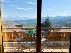 un tavolo e sedie su un balcone con vista di Appart 50m2 4 à 5 pers dans Chalet de charme a Vimines