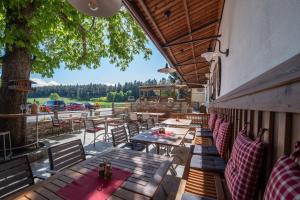 an outdoor patio with wooden tables and chairs at Zum Fally - Landgasthof in Kirchberg am Wechsel