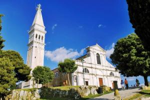 a church with a tower with a cross on it at EXCELSIOR Apartments Rovinj in Rovinj +116 photos