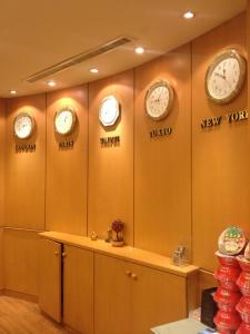 una habitación con cuatro relojes en la pared en Li Duo Hotel, en Tainan