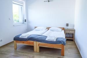 łóżko w pokoju z oknem w obiekcie Apartamenty Mazury w mieście Mrągowo