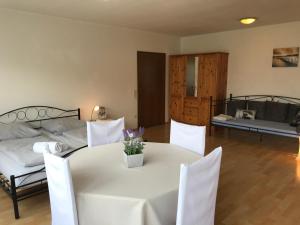 um quarto com uma mesa e cadeiras brancas e uma cama em Gästehaus Steinmann Apartment 2 Zimmer em Miltenberg