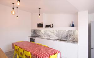 a kitchen with a red and white table and yellow chairs at Margueda in Alcains