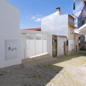 a white building with a gate in a courtyard at Margueda in Alcains