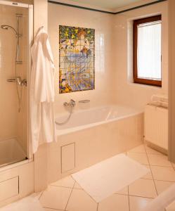 een badkamer met een bad en een schilderij aan de muur bij Landhaus zu Kürenberg in Bergham