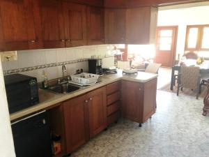 kuchnia z drewnianymi szafkami i blatem w obiekcie Los Corozos Apartment A2 Guavaberry Golf and Country Club w mieście Juan Dolio