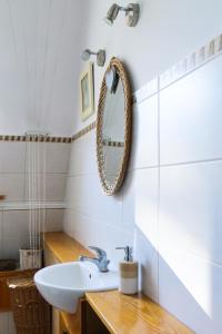 ein Bad mit einem Waschbecken und einem Wandspiegel in der Unterkunft Hello Apartments COZY & ART VIBES Targ Rybny in Danzig
