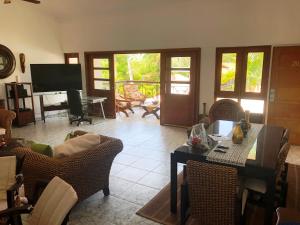salon z krzesłami, stołem i telewizorem w obiekcie Los Corozos Apartment A2 Guavaberry Golf and Country Club w mieście Juan Dolio