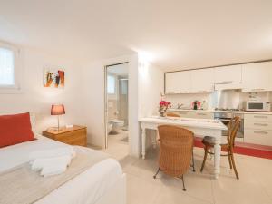 a bedroom with a bed and a desk and a kitchen at Sweet Studio IN GIARDINO in Padova