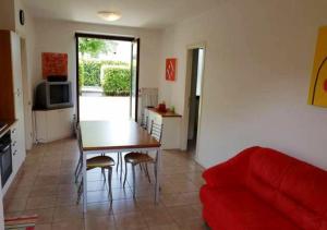 - un salon avec une table et un canapé rouge dans l'établissement Appartamento con Piscina a Lazise, à Lazise