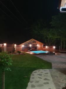 una casa con piscina por la noche en Lodge Zeleni svet, en Crni Vrh