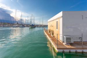 een dok met een gebouw en boten in een jachthaven bij AQUA RESORT GIULIANOVA - Houseboat Experience in Giulianova