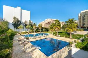 una vista aérea de una piscina con palmeras y edificios en Jardins da Rocha BeachView by Encantos do Algarve 19A, en Portimão