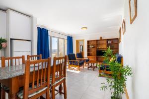Un comedor y una sala de estar con mesa y sillas. en Jardins da Rocha BeachView by Encantos do Algarve 19A, en Portimão