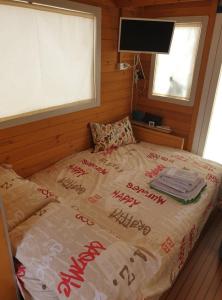 a bed in a room with a window and a television at HouseBoat Cagliari in Cagliari