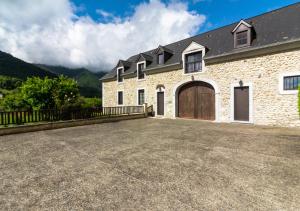 una gran casa de ladrillo con una gran entrada en La Ferme de Couty en Saint-Pé-de-Bigorre