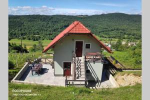 une petite maison avec un toit rouge sur une colline dans l'établissement vakantiehuis Zidanica, à Žužemberk