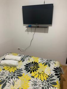 sala de estar con sofá y TV en la pared en Apto cerca del CC Titan Plaza 102, en Bogotá