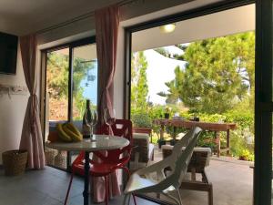 a room with a table and chairs and a glass door at Sweet n’ Boujee Studio Apartment with Varenda in Paphos City