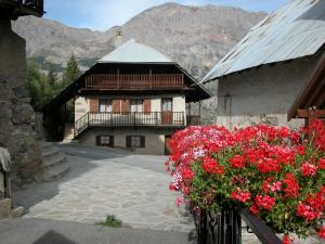 ein Gebäude mit roten Blumen davor in der Unterkunft Gîtes Vallouise Ecrins in Vallouise