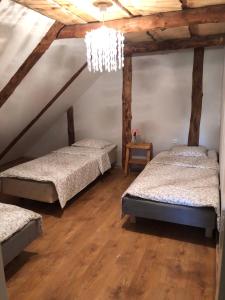 a attic room with two beds and a chandelier at Pärapõrgu puhkemaja in Miila