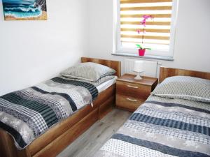 ジブヌベクにあるSłoneczne Tarasyのベッド2台 窓付きのベッドルーム1室