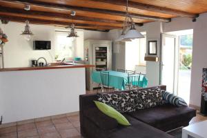 Una sala de estar con un sofá y una cocina. en Gite Le Cantou, en Saint-Maurice-de-Lignon
