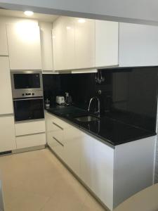 a kitchen with white cabinets and black counter tops at Casa da Ponte de Pedra in Aljezur +19 photos