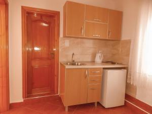 a small kitchen with wooden cabinets and a sink at Guest house Naser in Ulcinj +79 photos