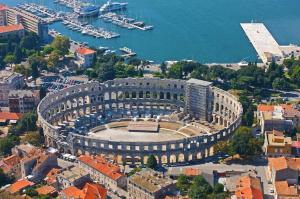 - une vue aérienne sur un grand bâtiment avec un port de plaisance dans l'établissement Villa Kamelija, à Fažana