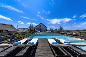 a swimming pool with lounge chairs on a wooden deck at Delta Boutique & Carmen Silva Resort in Crisan