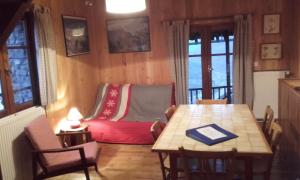 ein Wohnzimmer mit einem Tisch und einem roten Sofa in der Unterkunft Gîtes Vallouise Ecrins in Vallouise