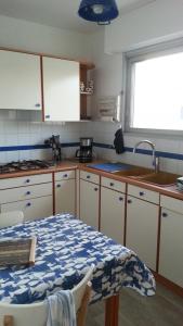 uma cozinha com um lavatório e uma mesa em Les Trinitaires em Sarzeau