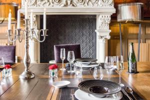 - une table en bois avec des assiettes et des verres à vin dans l'établissement Château La Thuilière, à Saint-Front-de-Pradoux