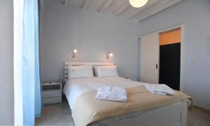 a bedroom with a bed with two towels on it at Nostos Beachfront Apartments & Studios in Agios Ioannis