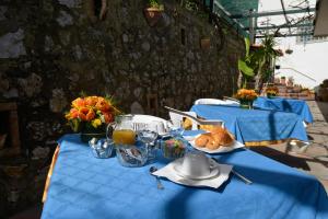 two blue tables with food and drinks on them at La Musa in Capri
