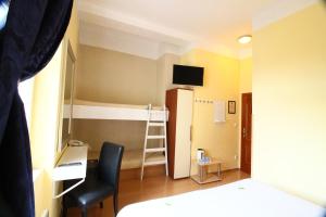 プラハにあるCity Lounge Crown Hotelのベッド、デスク、二段ベッドが備わる客室です。