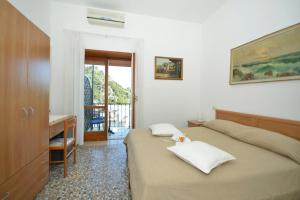 a bedroom with two beds and a desk and a window at La Musa in Capri