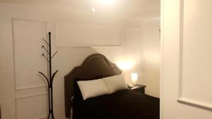 a bedroom with a black bed with a white pillow at Sage Hills Motel in Cache Creek