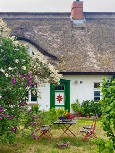ein Haus mit einer grünen Tür, einem Tisch und Stühlen in der Unterkunft Ferienwohnung Sierke in Wieck