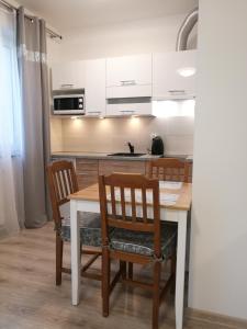 a kitchen with a wooden table and two chairs at Szafarnia/Św Barbary 11 in Gdańsk