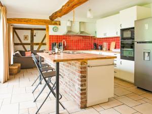 a kitchen with white cabinets and a brick wall at Lavish Holiday Home in Malmedy with Sauna in Longfaye