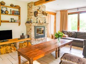 a living room with a fireplace and a wooden table at Lavish Holiday Home in Malmedy with Sauna in Longfaye