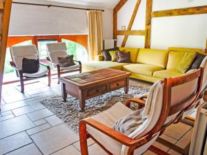 a living room with a yellow couch and chairs at Lavish Holiday Home in Malmedy with Sauna in Longfaye