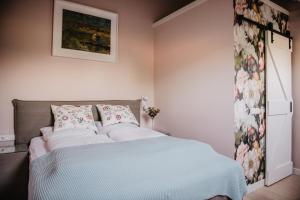 a bedroom with a bed and a painting on the wall at De Verloren Sinjoor in Bladel