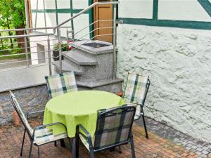 une table et des chaises vertes sur la terrasse dans l'établissement Attractive apartment in R beland in the Upper Harz, à Elbingerode