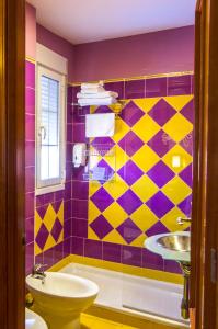 a bathroom with a purple and yellow tiled wall at Midama in Chillarón de Cuenca