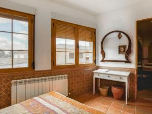 - une chambre avec un lit, un miroir et un bureau dans l'établissement Belvilla by OYO Casa La Espartera, à Ciudad Real