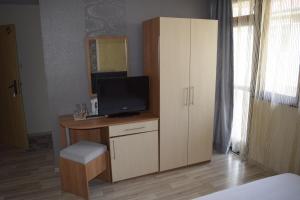 a bedroom with a desk with a television and a cabinet at Guest House Gloria in Nesebar