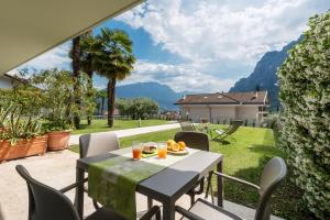 - une table et des chaises sur la terrasse d'une maison dans l'établissement La Busa Apartments - Garda Chill Out, à Riva del Garda
